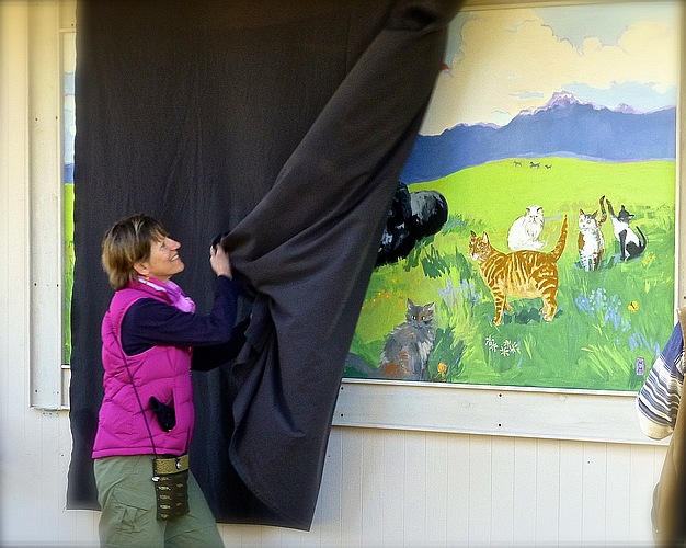 Artist Marian Morris standing beside the unveiled Rainbow Bridge mural at Safe Haven