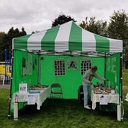 PFOA bright green and white striped fundraising tent at a community event